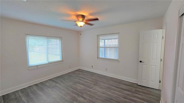 empty room featuring ceiling fan and dark hardwood / wood-style flooring