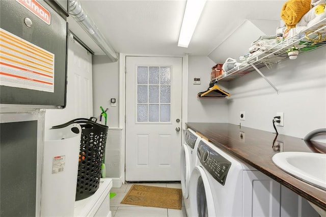 laundry room featuring sink, washing machine and clothes dryer, and light tile patterned floors