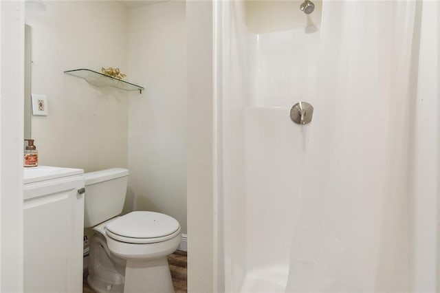 bathroom featuring toilet, curtained shower, and wood-type flooring