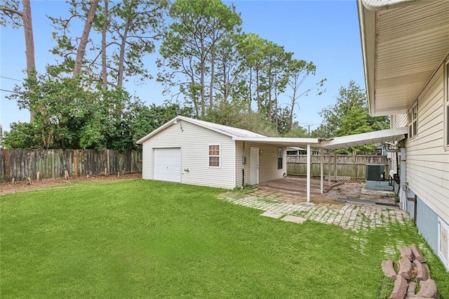 view of yard featuring an outdoor structure, a garage, central air condition unit, and a patio