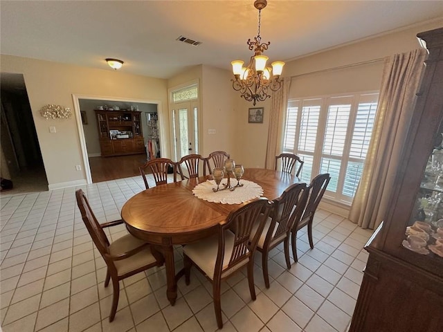 tiled dining room featuring an inviting chandelier