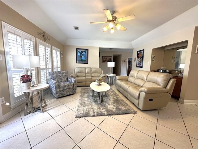 living room with light tile patterned floors, ceiling fan, and sink