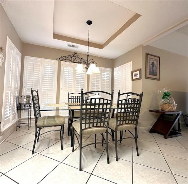 dining room featuring a wealth of natural light, an inviting chandelier, and a tray ceiling