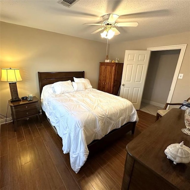 bedroom featuring a textured ceiling, ceiling fan, and dark hardwood / wood-style floors