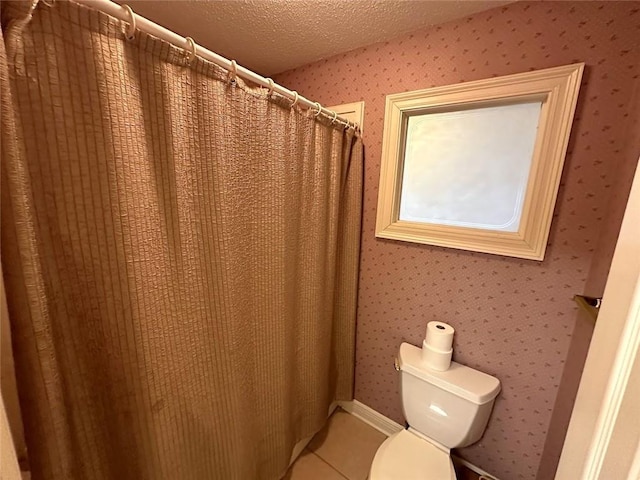 bathroom featuring toilet, a textured ceiling, and curtained shower