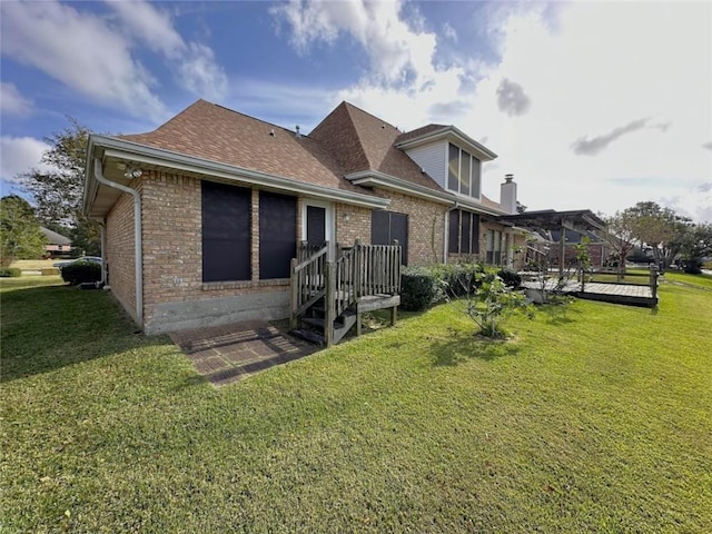 back of property featuring a lawn and a deck