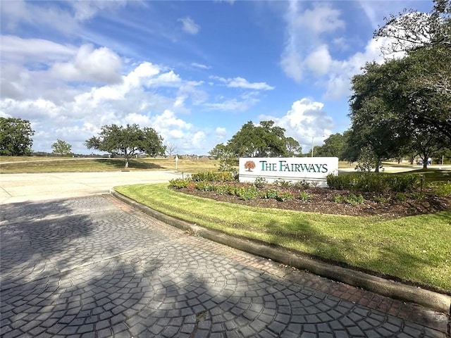 community / neighborhood sign featuring a lawn