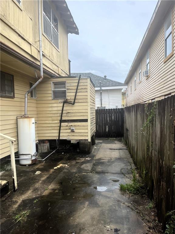 view of property exterior with a patio and water heater