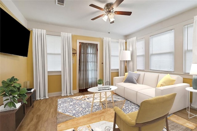 living room with light hardwood / wood-style floors and ceiling fan