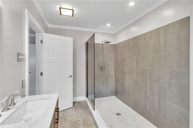 bathroom featuring vanity, crown molding, baseboards, and tiled shower