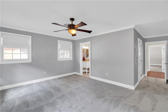 carpeted spare room with baseboards, a healthy amount of sunlight, ceiling fan, and crown molding