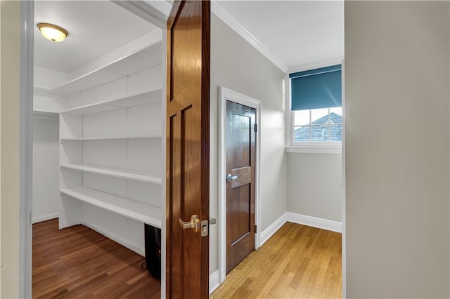 interior space with crown molding, light wood-style floors, and baseboards