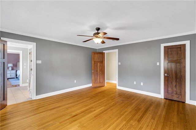 unfurnished room with ceiling fan, baseboards, ornamental molding, and light wood finished floors