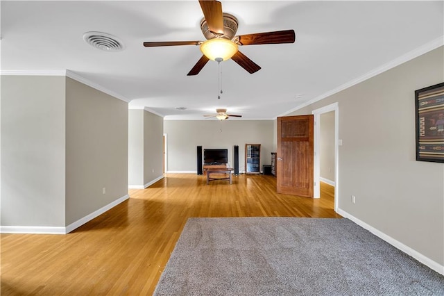 unfurnished living room with visible vents, baseboards, wood finished floors, and crown molding