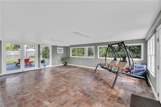 sunroom featuring french doors, a wealth of natural light, and a wall mounted AC