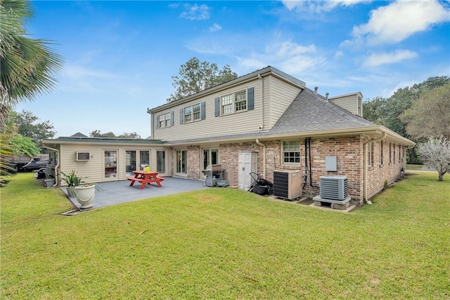 back of property featuring a patio, brick siding, central AC, and a lawn