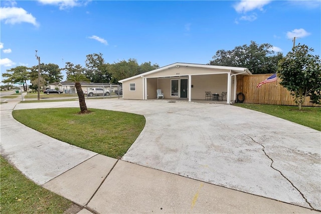 ranch-style house featuring a front yard and a carport