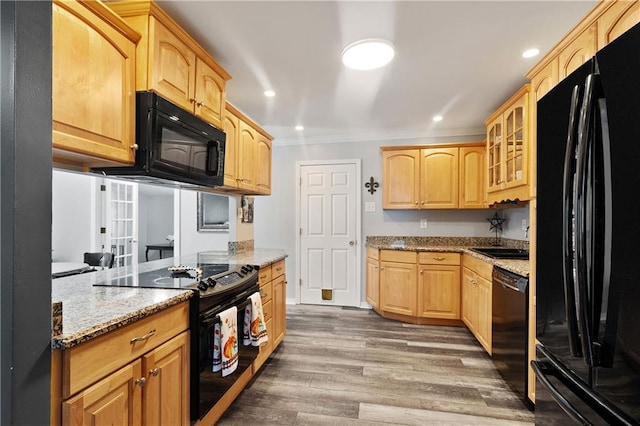 kitchen featuring light stone counters, ornamental molding, dark hardwood / wood-style floors, black appliances, and sink