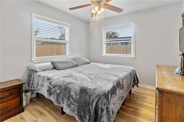 bedroom featuring multiple windows, light wood-type flooring, and ceiling fan