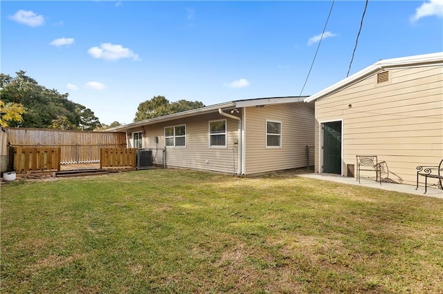 rear view of property featuring a wooden deck, central AC, and a yard