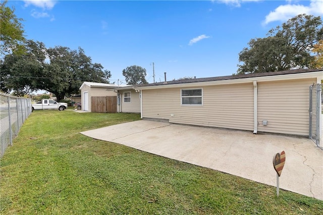 back of house with a patio area and a lawn