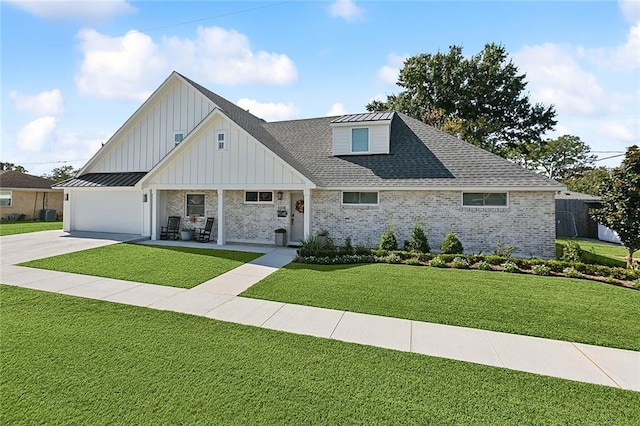 view of front of house featuring covered porch, a front yard, and a garage