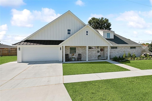 view of front of house with a front yard, a porch, and a garage