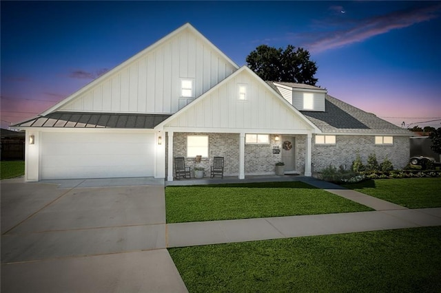 view of front of property with a lawn, a porch, and a garage