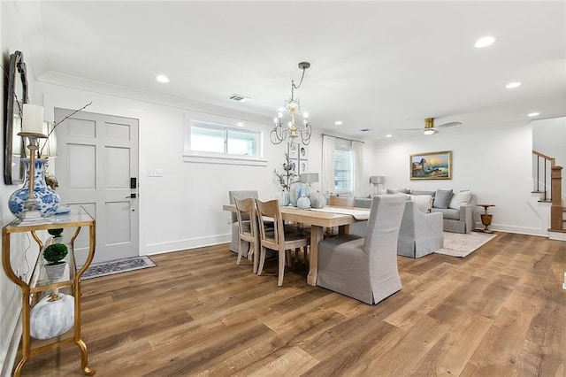 dining area featuring hardwood / wood-style floors, ceiling fan with notable chandelier, and ornamental molding