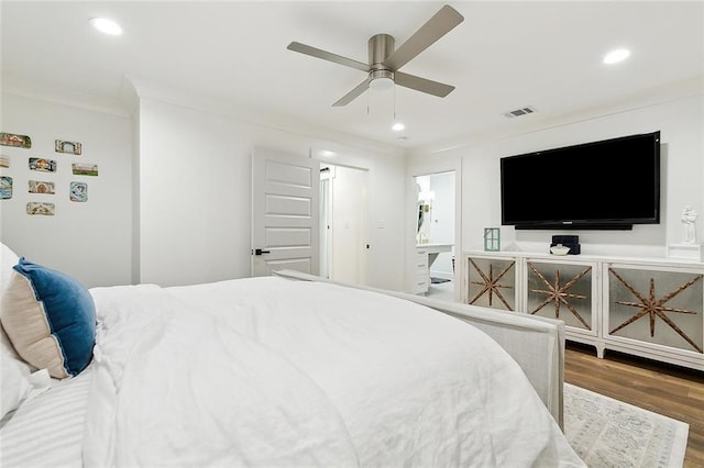 bedroom with hardwood / wood-style floors, ceiling fan, and ornamental molding