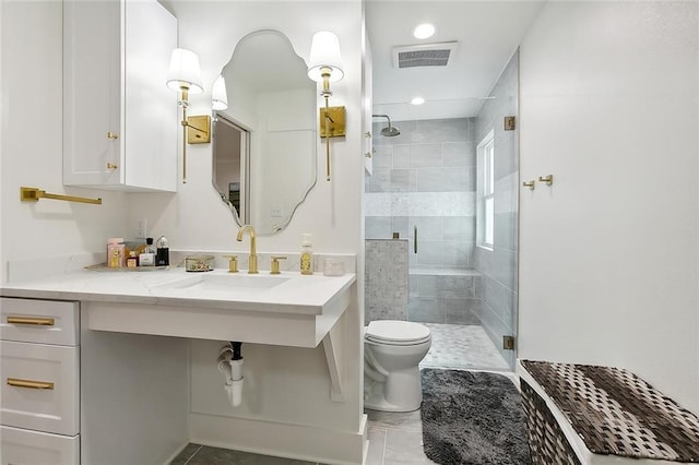 bathroom with tile patterned flooring, vanity, toilet, and walk in shower