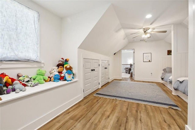 bedroom featuring light hardwood / wood-style flooring, ceiling fan, and lofted ceiling