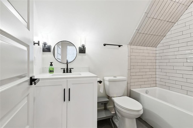 full bathroom with tiled shower / bath, vanity, vaulted ceiling, and toilet