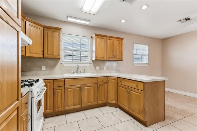 kitchen featuring light tile patterned flooring, sink, kitchen peninsula, white stove, and exhaust hood