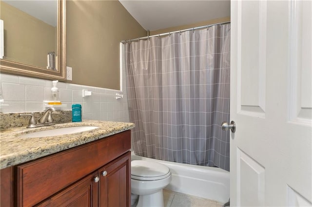 full bathroom with tile walls, toilet, vanity, shower / tub combo with curtain, and tile patterned flooring