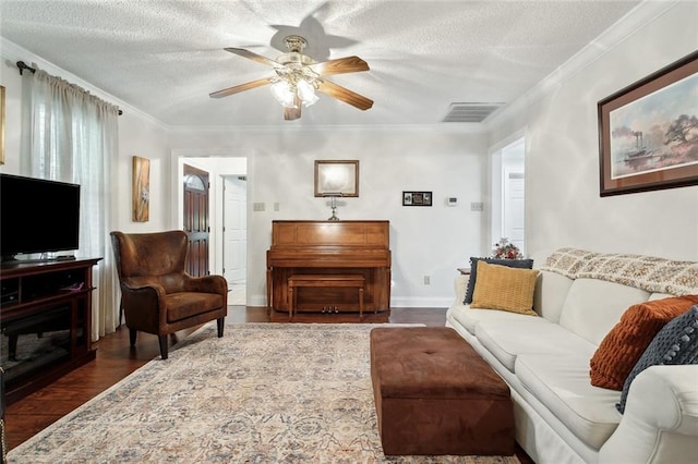 living room with ornamental molding, a textured ceiling, dark wood-type flooring, and ceiling fan