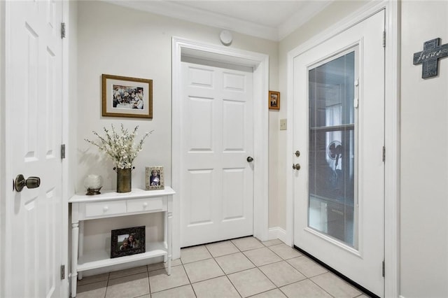 doorway with ornamental molding and light tile patterned floors