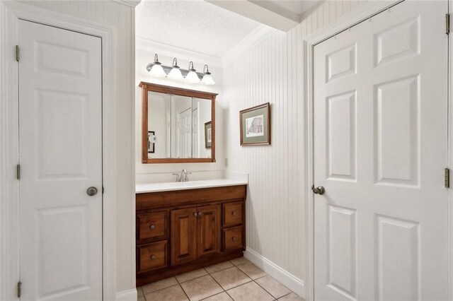 bathroom with vanity, crown molding, tile patterned flooring, and wooden walls