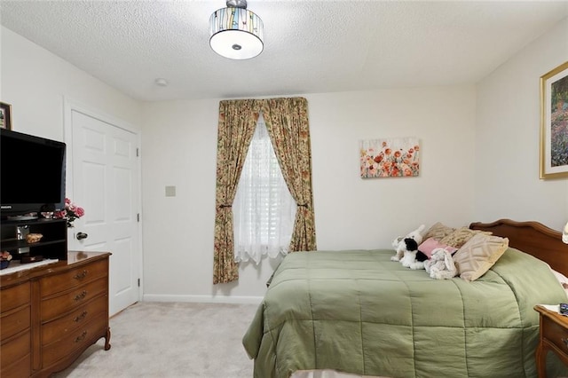 bedroom featuring light carpet and a textured ceiling