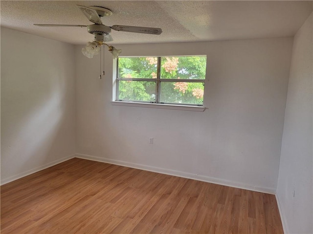 unfurnished room featuring ceiling fan, light hardwood / wood-style flooring, and a textured ceiling