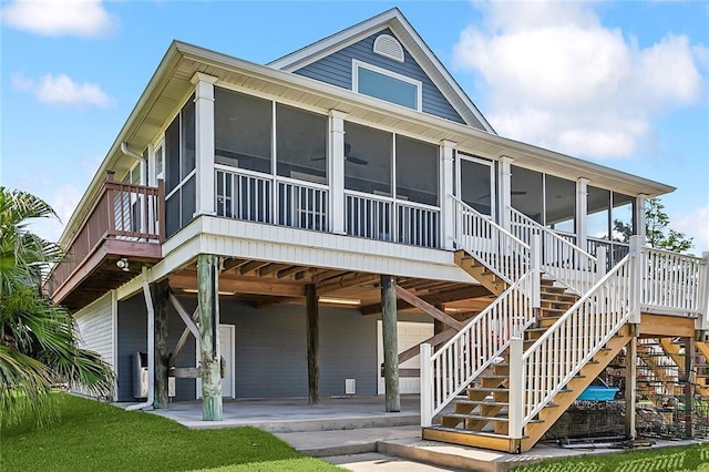 view of front of home featuring stairs, a patio area, and a sunroom