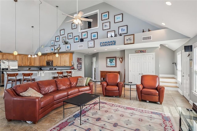 living area featuring a ceiling fan, lofted ceiling, visible vents, and baseboards