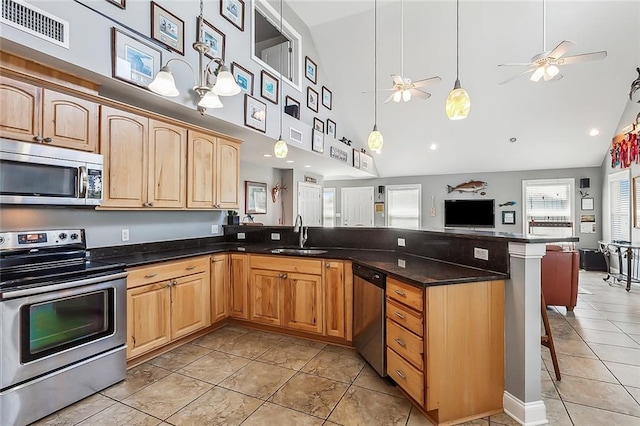 kitchen with a breakfast bar area, a sink, visible vents, open floor plan, and appliances with stainless steel finishes