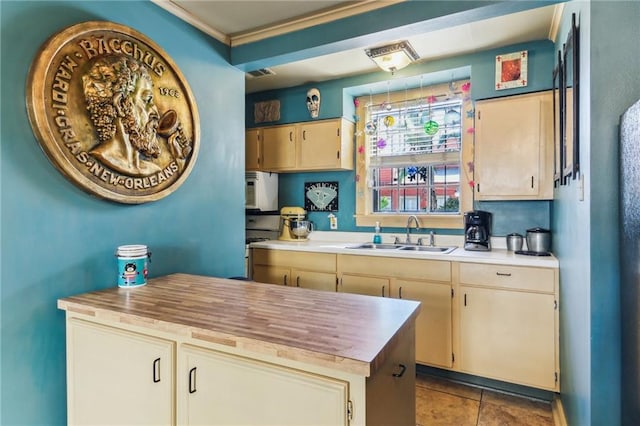 kitchen with wooden counters, sink, and light tile patterned floors