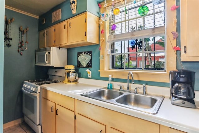 kitchen with white appliances, sink, and light brown cabinets