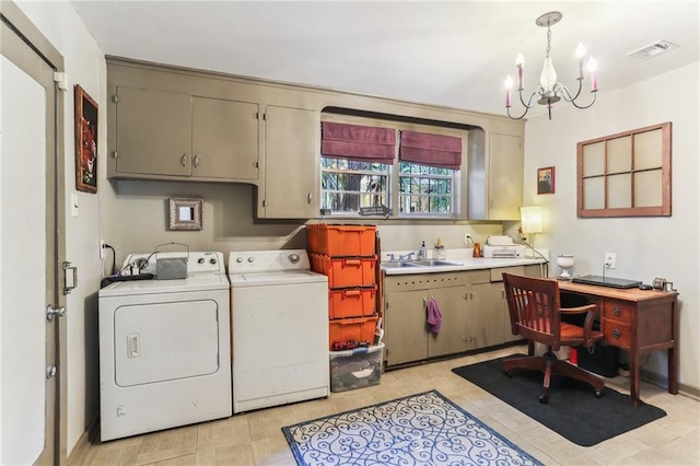 laundry room featuring cabinets, light tile patterned floors, an inviting chandelier, washing machine and clothes dryer, and sink