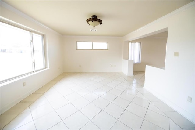 empty room featuring ornamental molding and light tile patterned floors