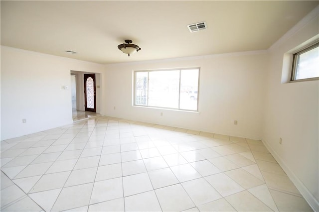 tiled empty room with crown molding and a wealth of natural light