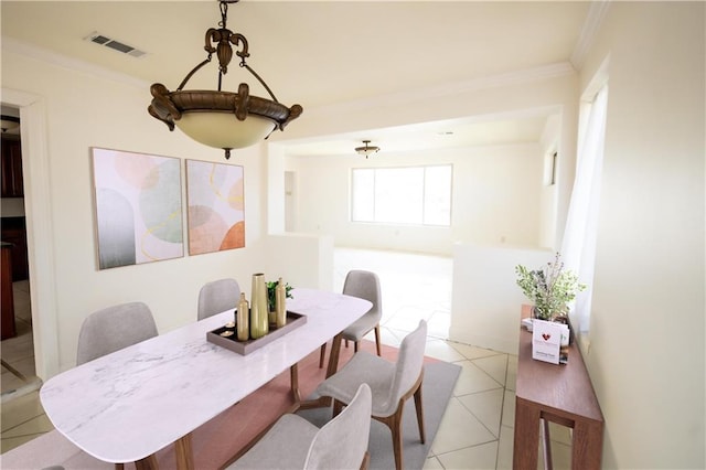 tiled dining space featuring ornamental molding