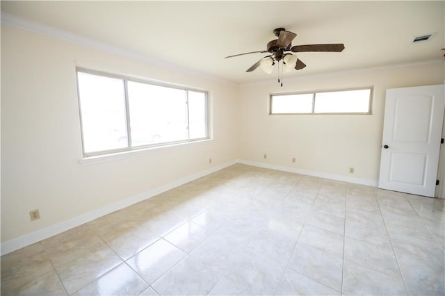 spare room featuring ceiling fan, ornamental molding, and light tile patterned floors